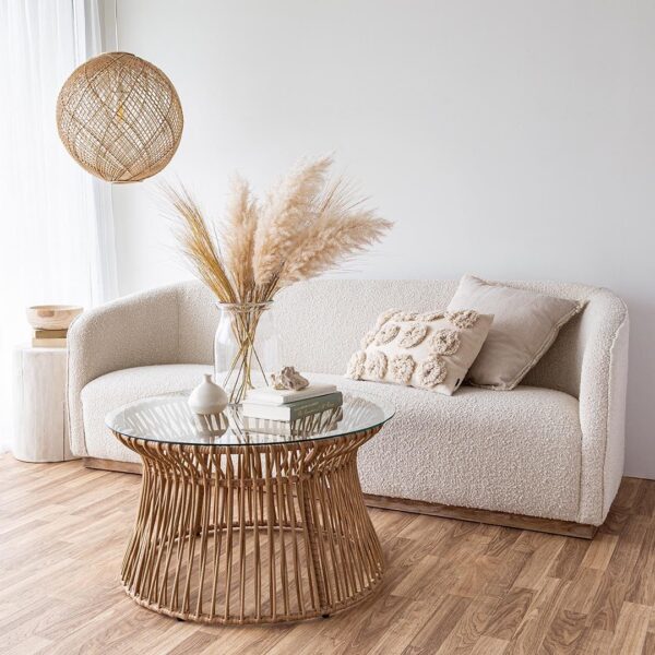 Woman reading on cream boucle fabric sofa with silver round coffee table in front